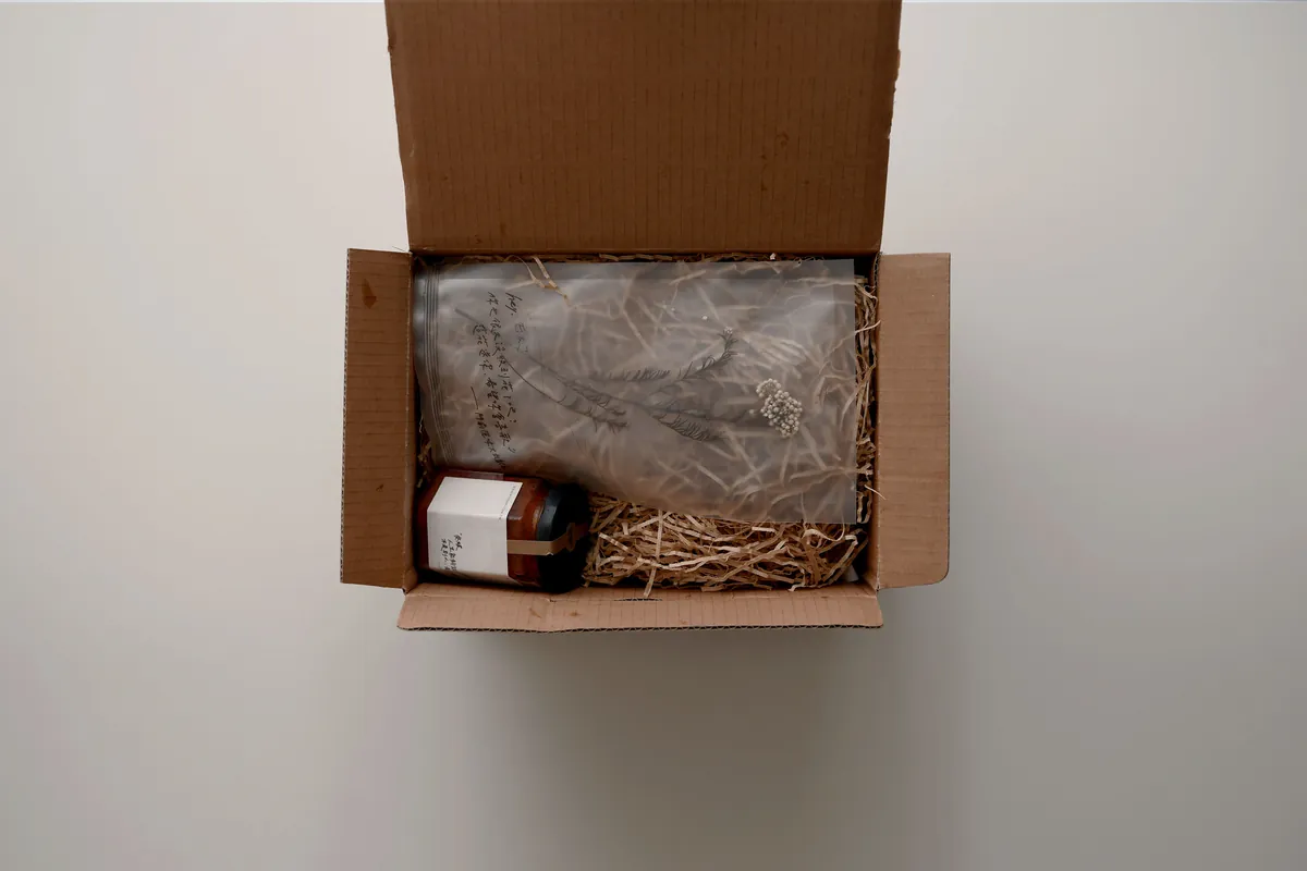 打開的門前隱味宅配紙箱,裡面有紙包好的牛肉和一罐辣椒